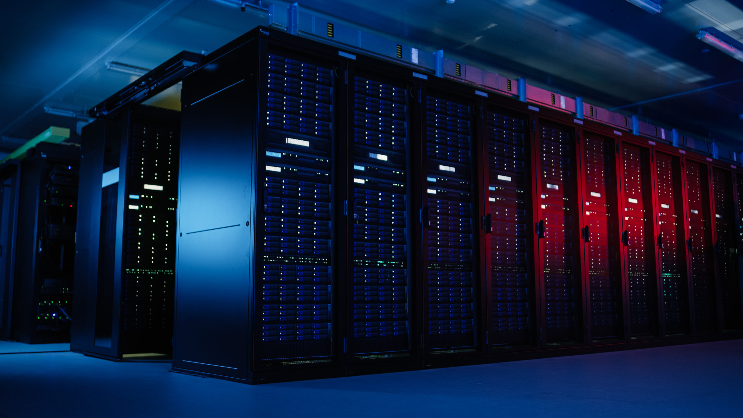  Rows of computer servers in dark room partly illuminated by red light illustrate concept of threat from ransomware attacks.
